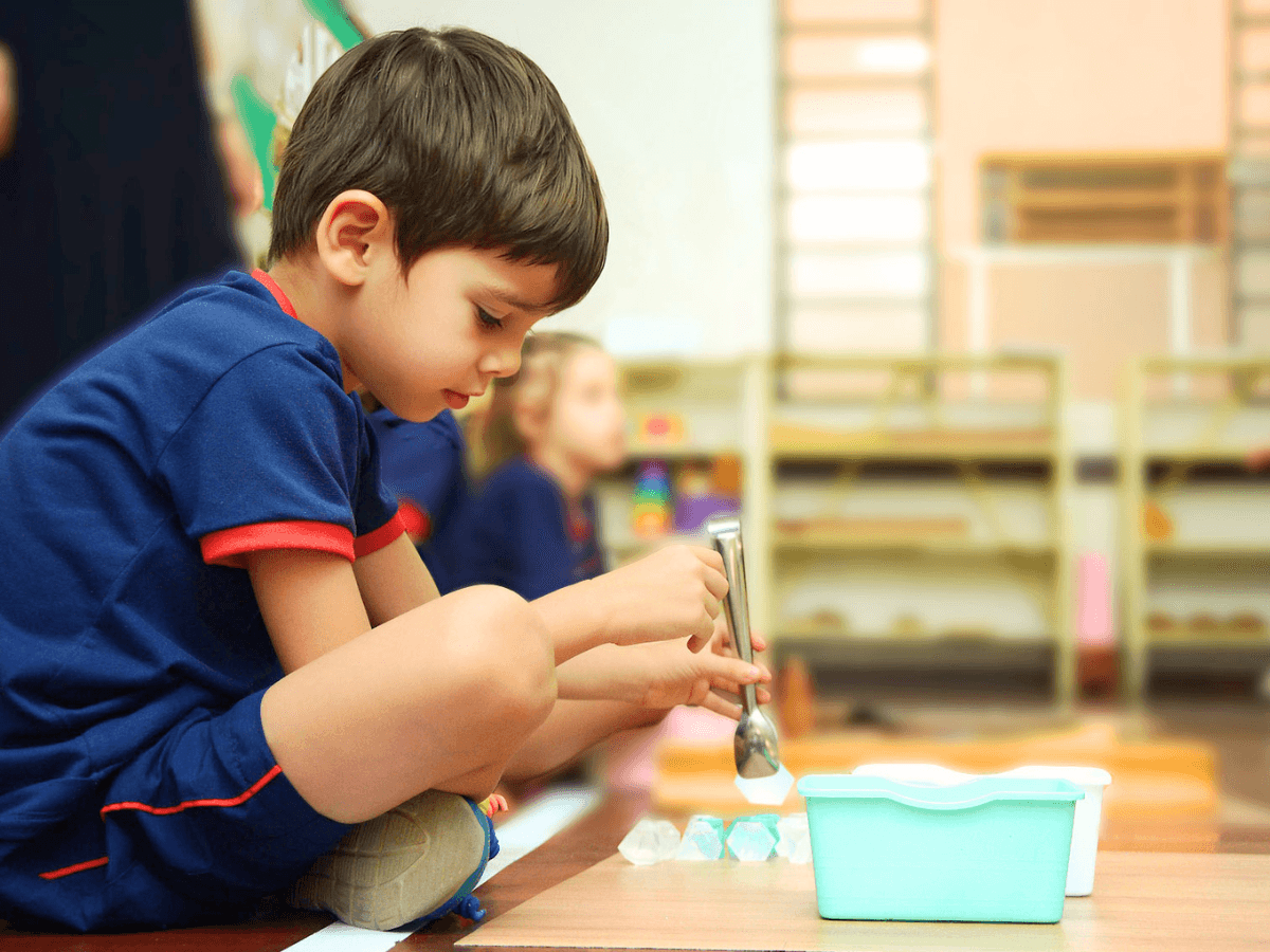Aluna manuseando material sensorial Montessori (torre rosa)